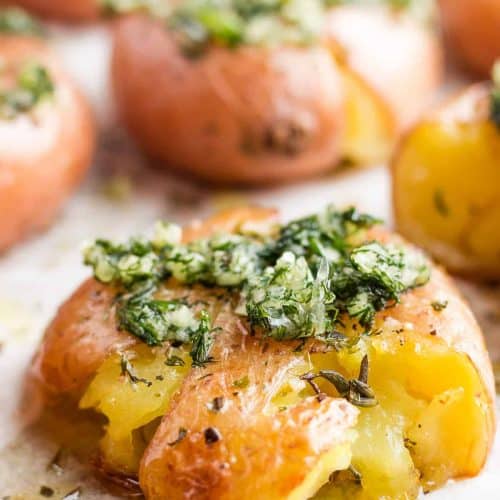 close-up of smashed potato topped with dill sauce.