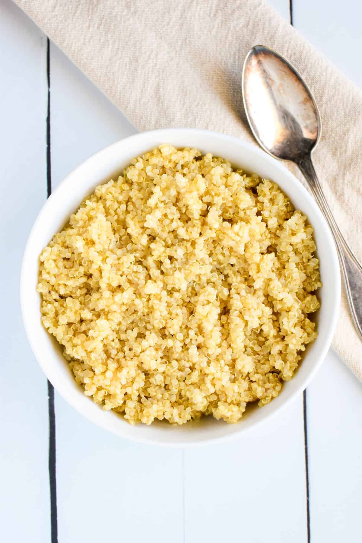 Cooked quinoa in a bowl with a spoon.