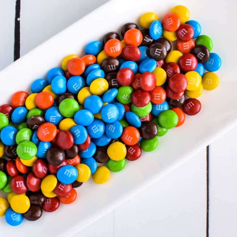 Overhead view of M&M's on a white plate.