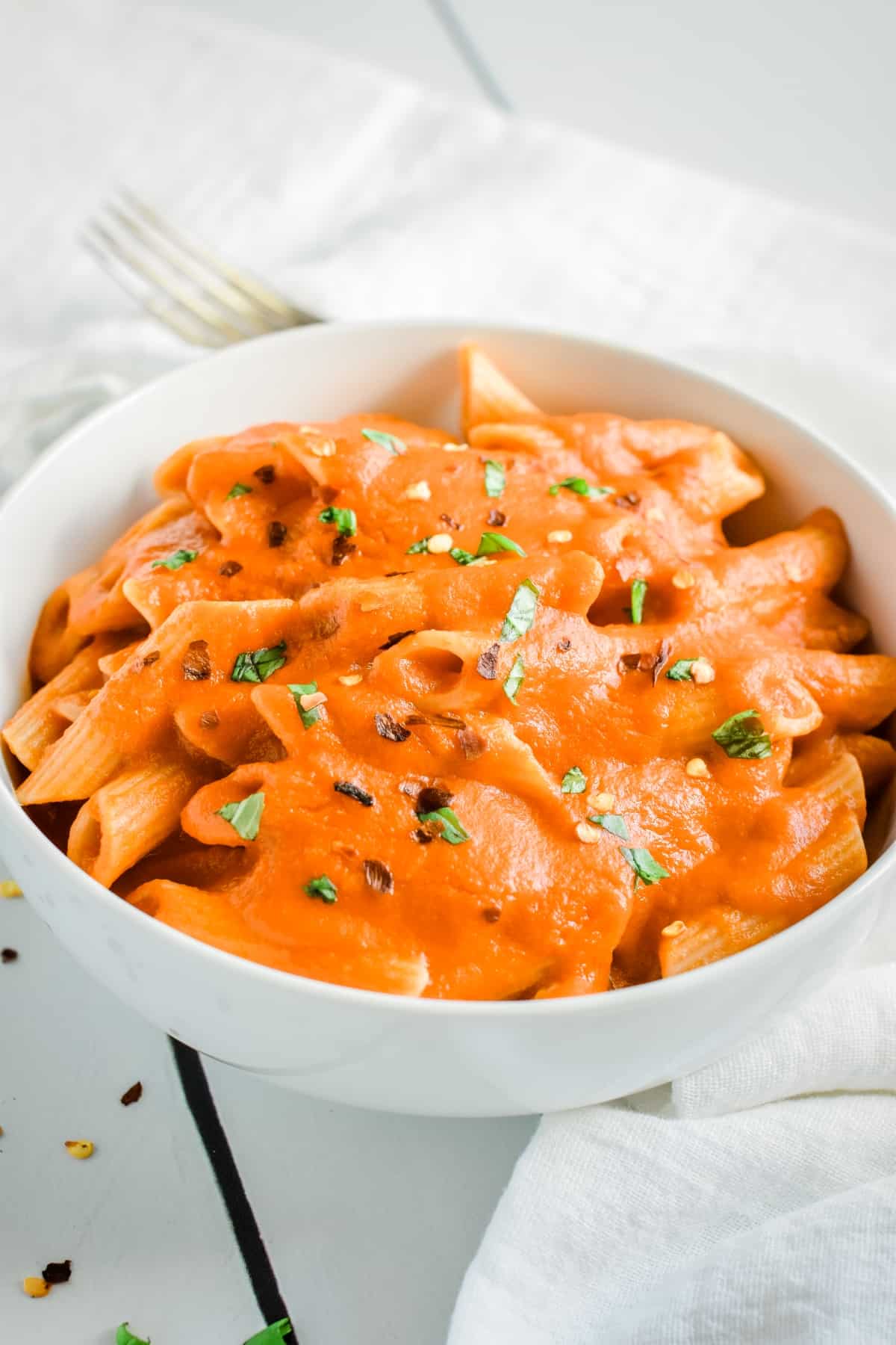 Vodka sauce over pasta in a bowl.