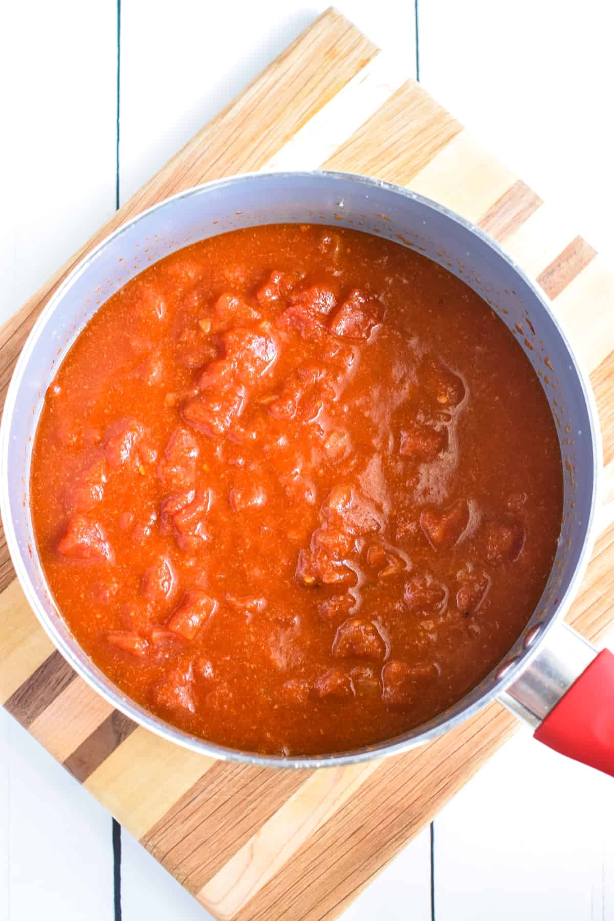 Diced tomatoes and ingredients in a pan.