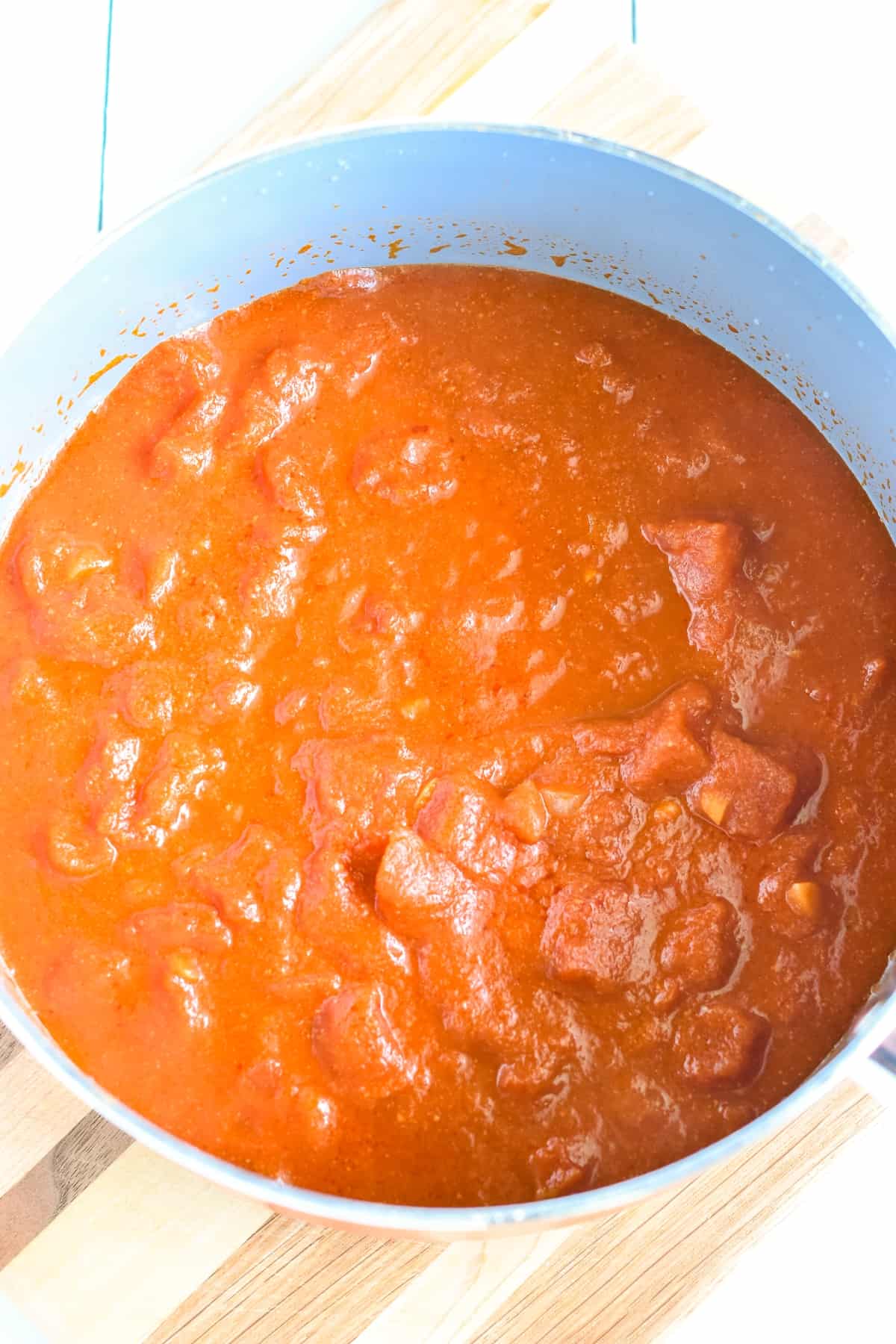Cooked tomatoes and ingredients in a pan.
