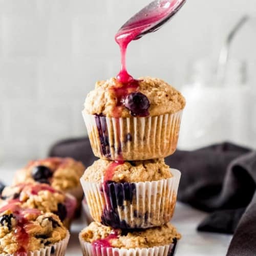 Healthy oatmeal lemon blueberry muffins stacked on a countertop.