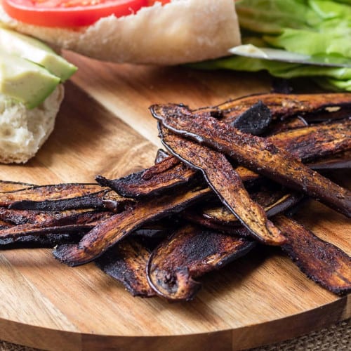 eggplant bacon slices on a wooden board.