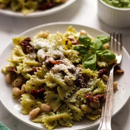 Vegan pesto pasta on a plate with a fork.