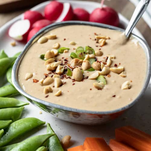 Healthy Peanut Sauce White Bean Dip in a bowl with vegetables.