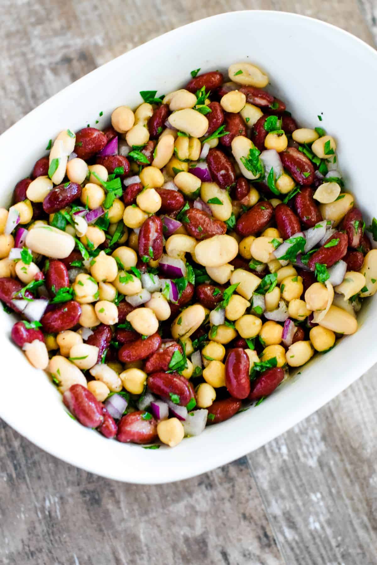 bean salad in white serving dish after being mixed together.
