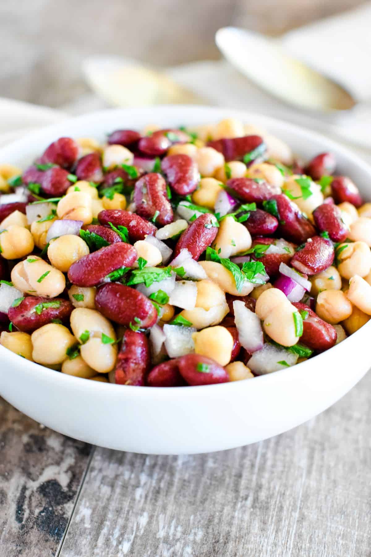 close-up front view of bean salad in a white bowl.