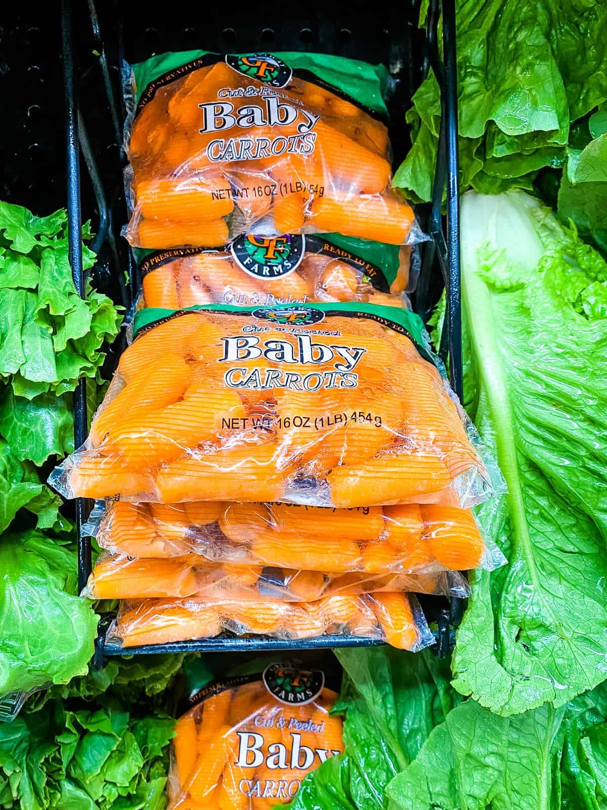Bags of baby carrots on supermarket shelves.