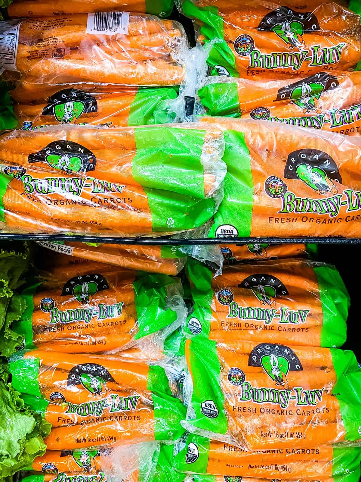 Bags of carrots on grocery store shelves.