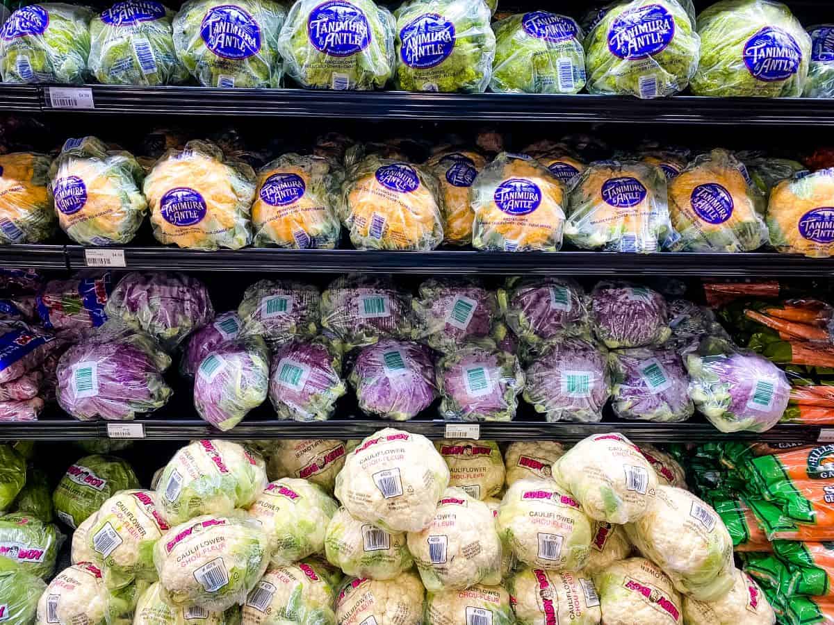Different types of cauliflower on supermarket shelves.