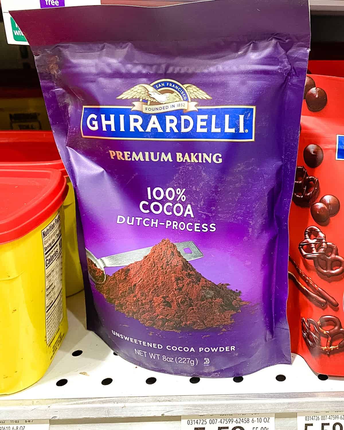 Bag of Ghirardelli Cocoa Powder on a supermarket shelf.