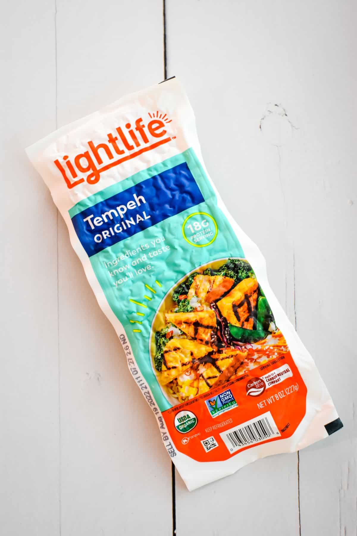 Package of Tempeh on wood surface.