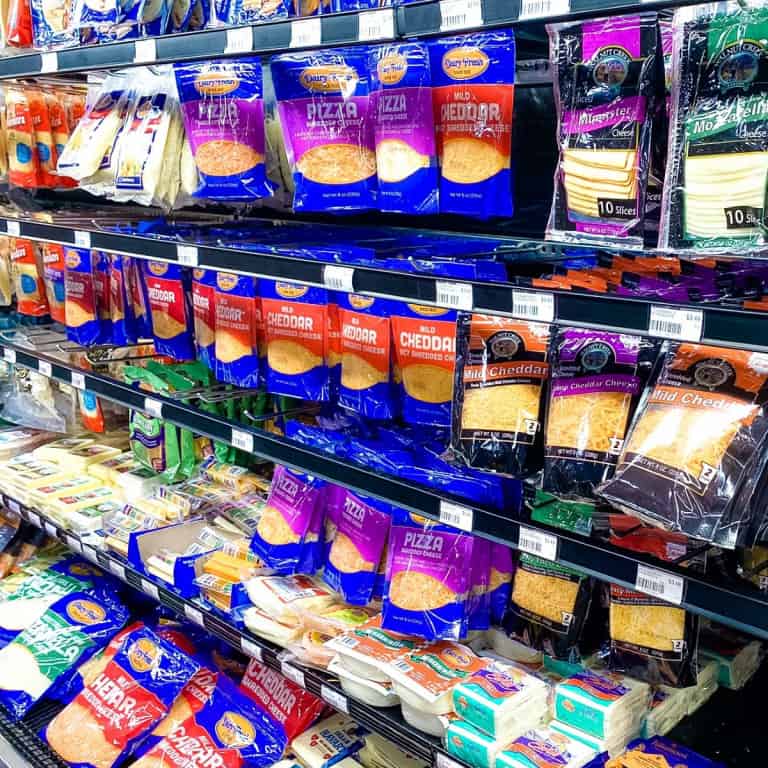 Shredded cheese on supermarket shelves close up.