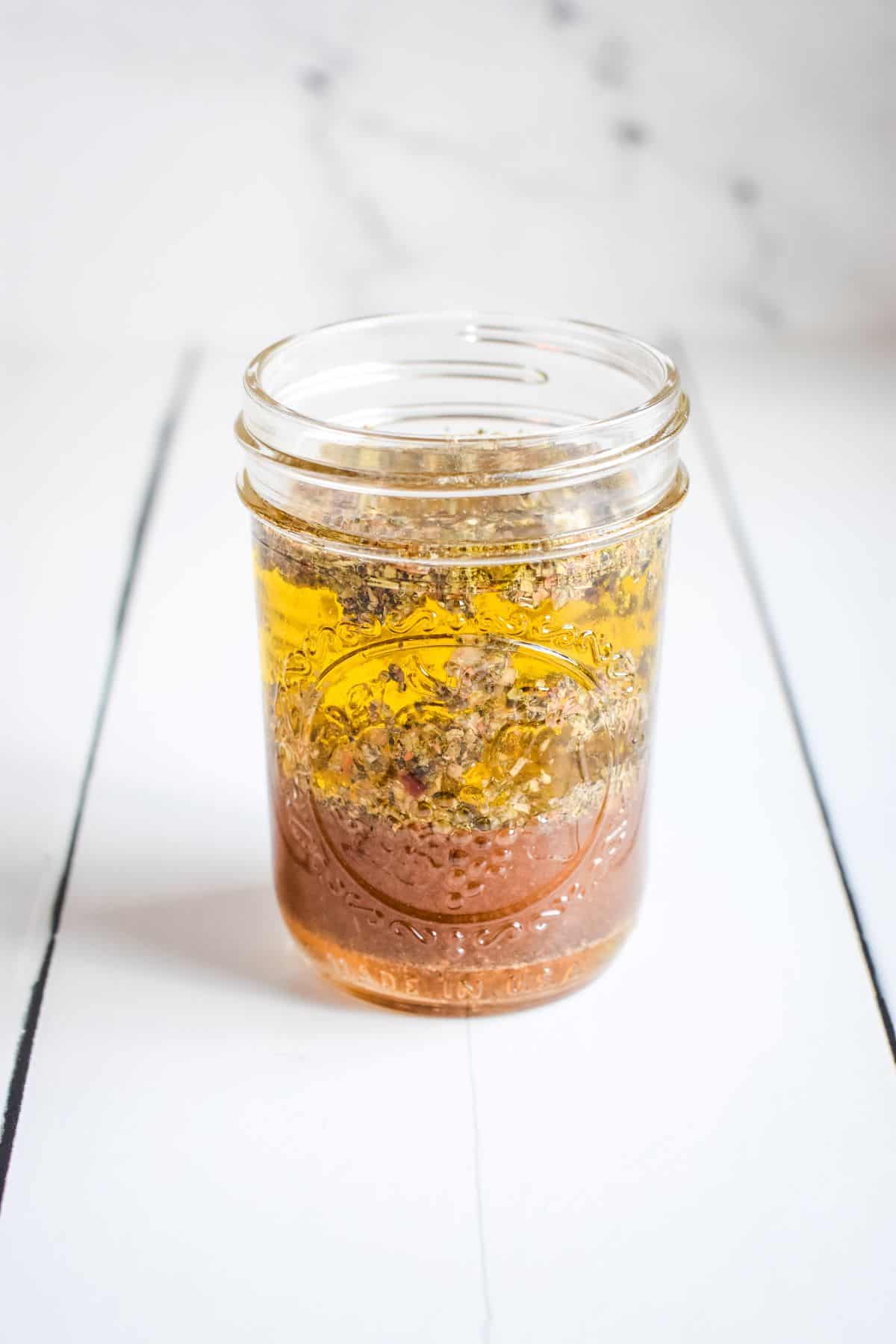 Oil and spices in a Mason jar for salad dressing.