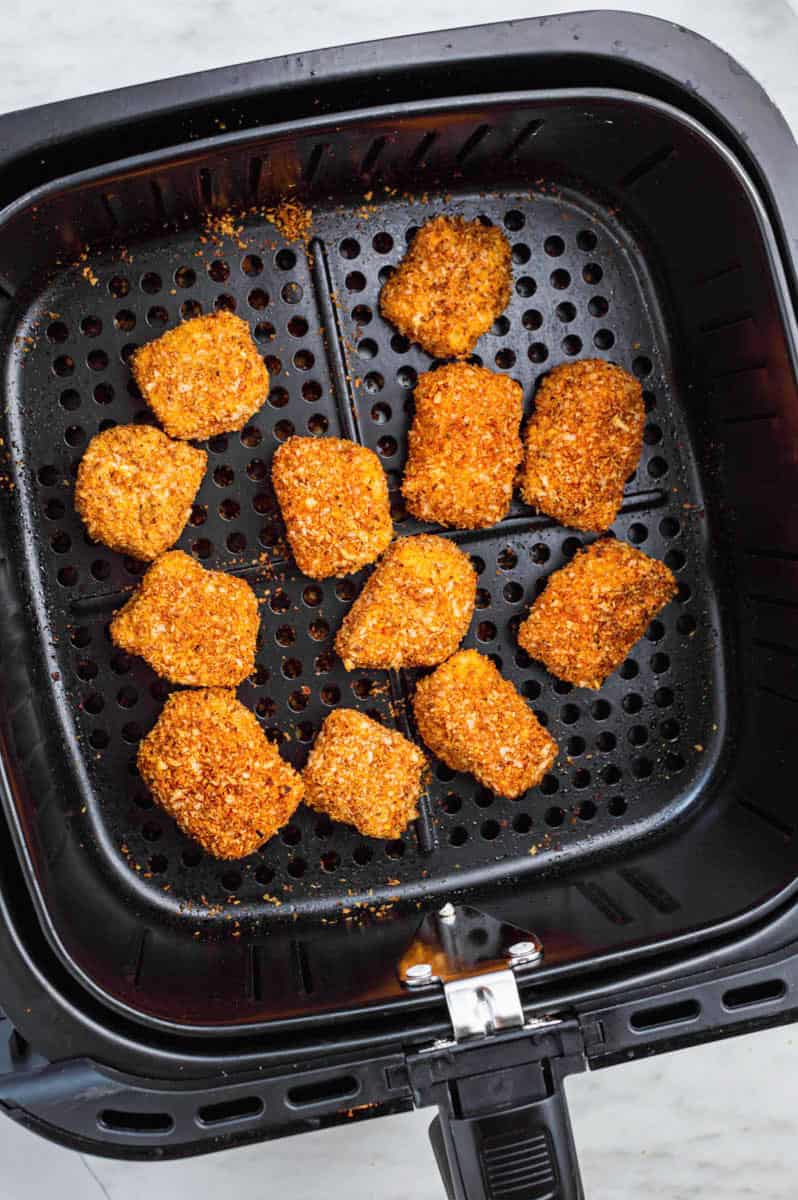 Tofu nuggets in air fryer basket.