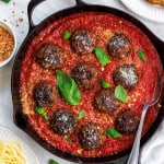 overhead close-up of meatballs in sauce with a spoon in it.
