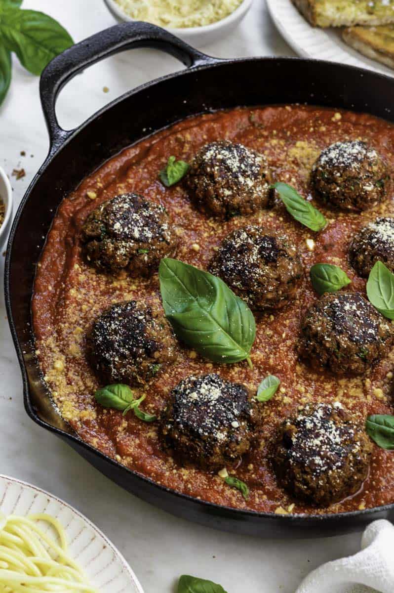 Beyond meat meatballs simmered in marinara sauce and topped with fresh basil and a sprinkle of vegan parmesan.