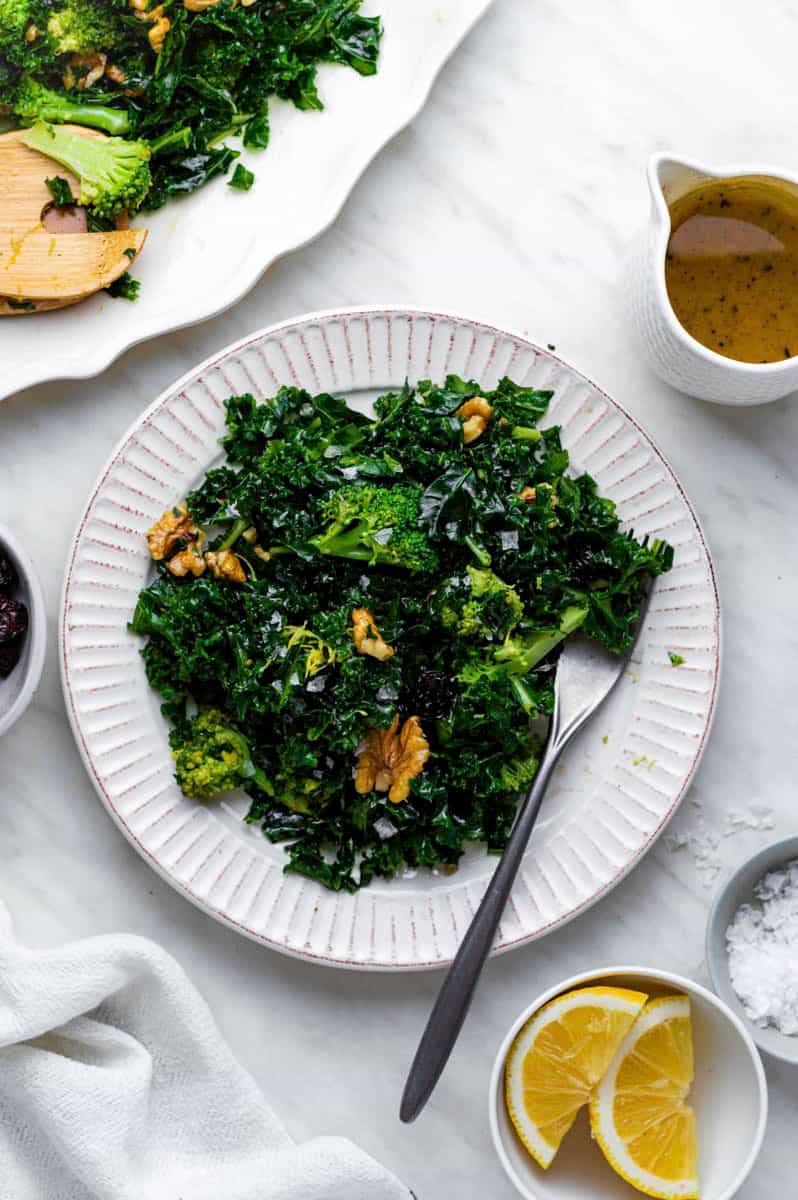 Chick fil a superfood kale salad served on a white plate with a fork on the side.