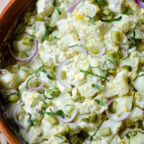 Pesto potato salad with eggs in a bowl.