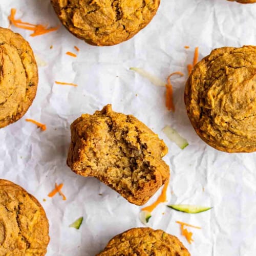 Zucchini carrot apple muffins on parchment paper.