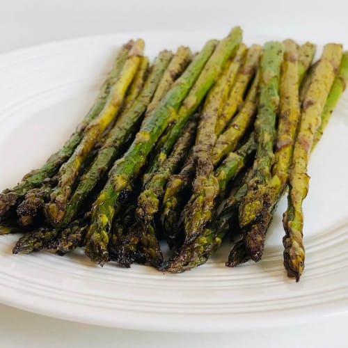 Balsamic baked asparagus on a white plate.