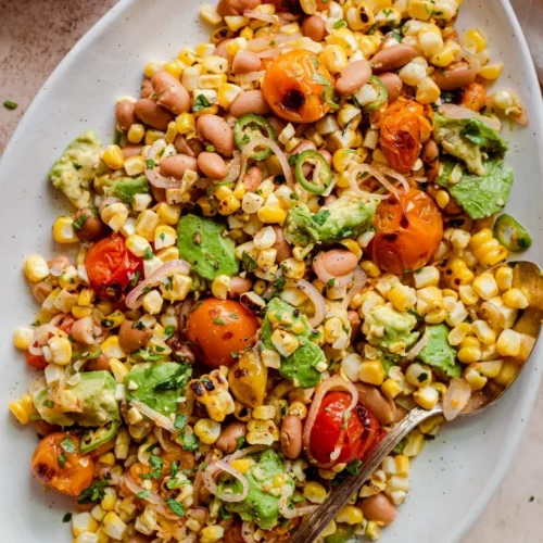 Grilled corn and tomato salad on a plate.