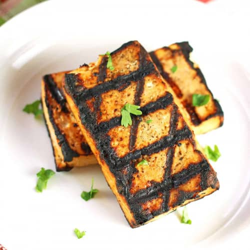 Grilled tofu steaks on a plate.