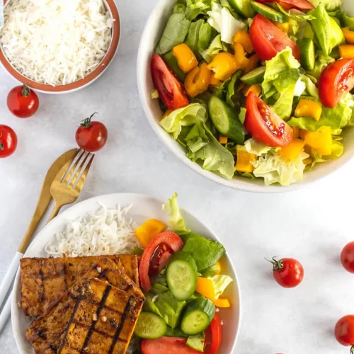 Grilled tofu on a plate with a salad.