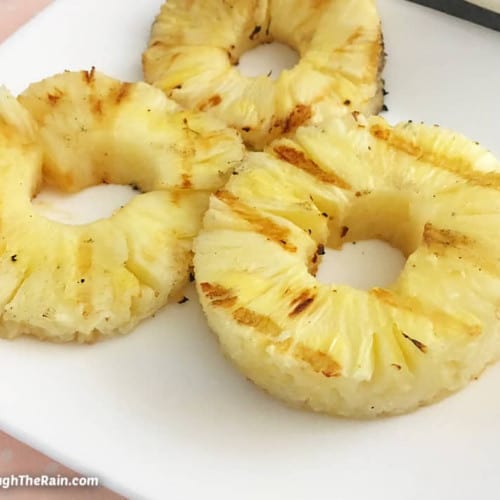 Grilled pineapple on a white plate.