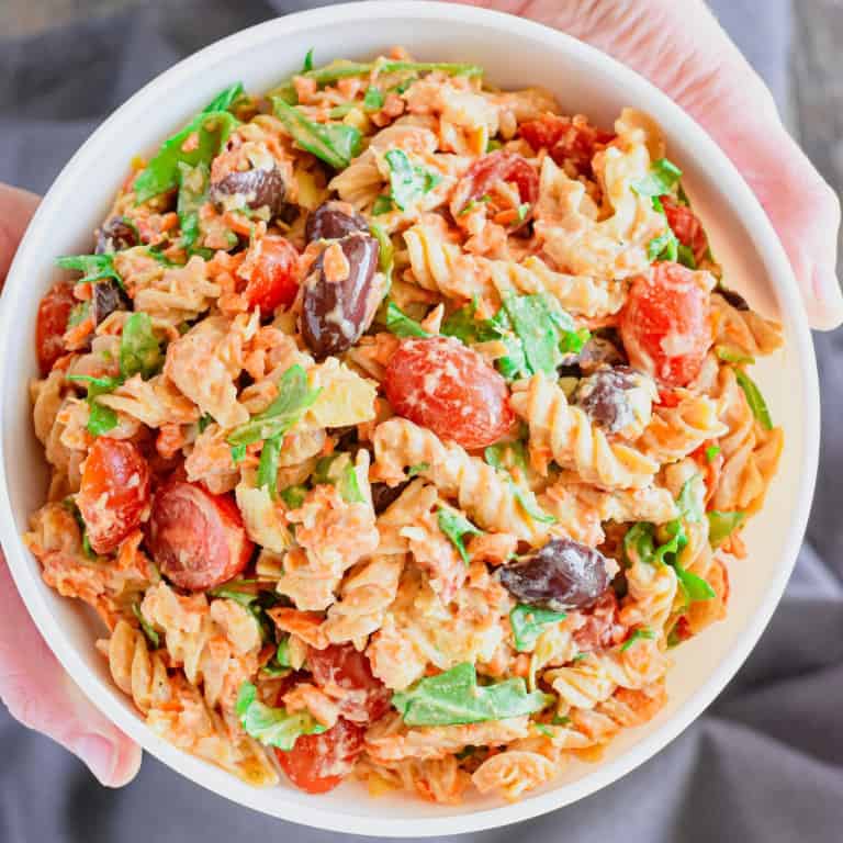 Close-up overhead of a hand lifting a pasta salad.