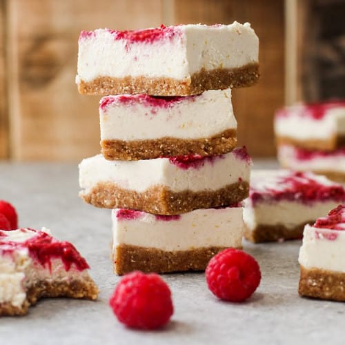 Raspberry Cheesecakes stacked on a surface.