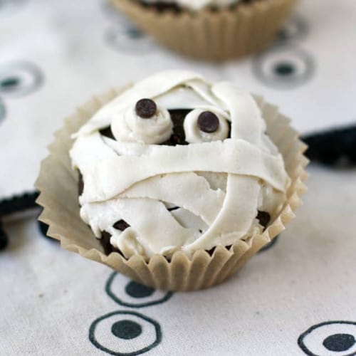 Spooky Mummy Cupcakes on a kitchen towel.