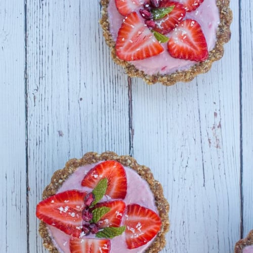 Mini Strawberry Tarts on a wood surface.