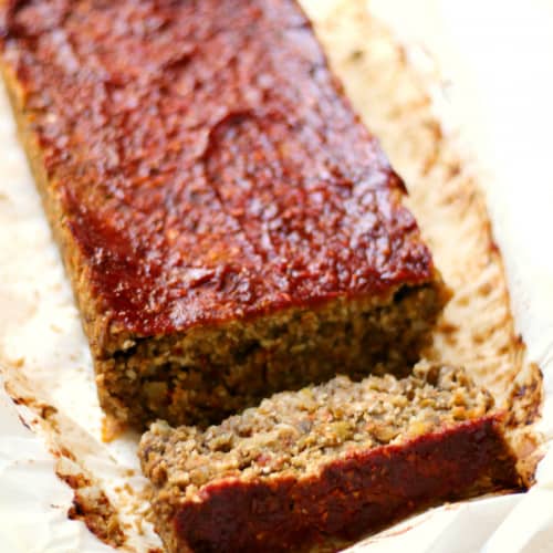 cauliflower lentil loaf with a slice cut off and lying down in the front.