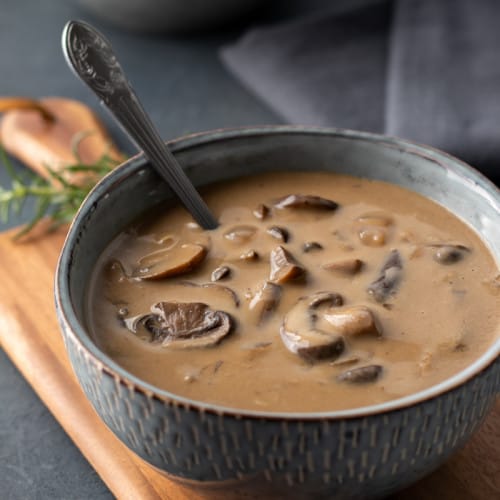 vegan cream of mushroom soup in a bowl on a wooden board.