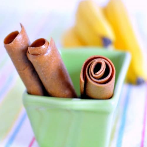 3 peanut butter banana fruit roll-ups sticking out of a green container.