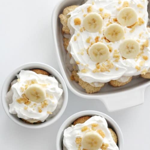 two bowls of Southern banana pudding with a square dish of more behind them.