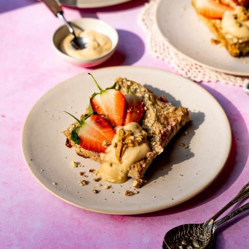 vegan baked oats on a plate with two spoons on top of each other in front.