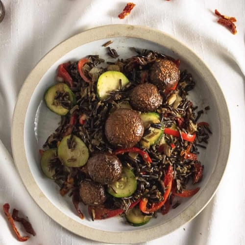 ovherhead of wild rice with mushrooms in a bowl on a kitchen towel.