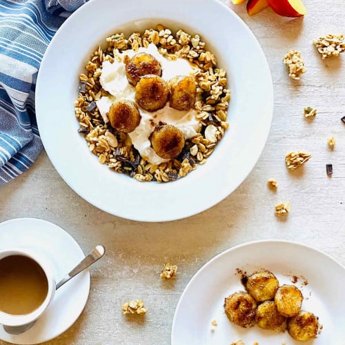 air fryer bananas with some granola in a bowl and some on a plate.