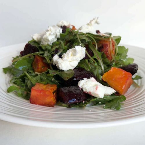 front view of beetroot and sweet potato salad on a white plate.