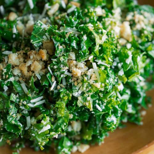 Kale salad in a wooden bowl with parmesan.