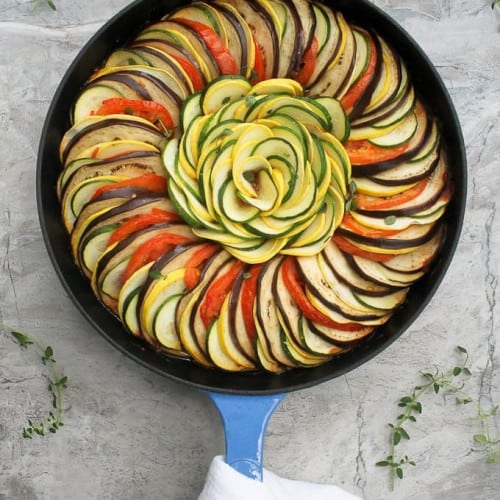 overhead of ratatouille in a skillet with handle wrapped with a towel.