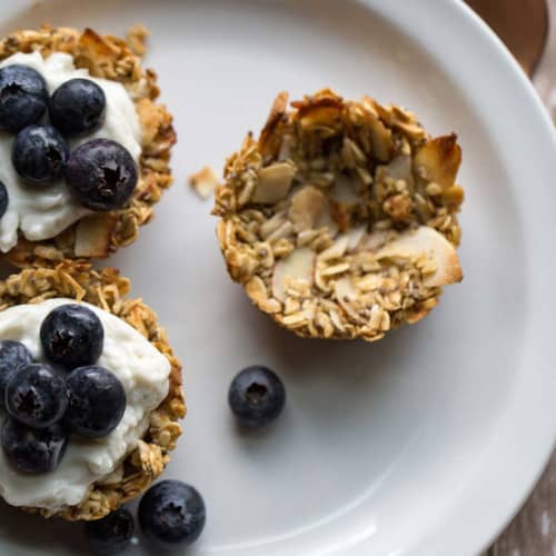 Oatmeal cups with cream and blueberries on a plate.