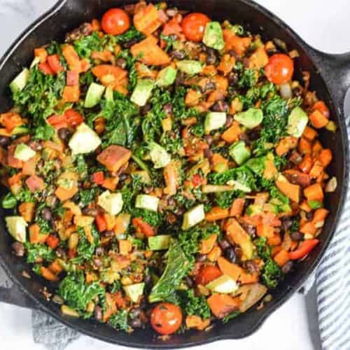 Potatoes and vegetable skillet in a cast iron pan on the table.