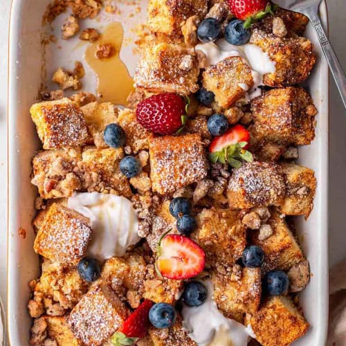 French toast casserole with a portion missing and a serving spatula to the side.