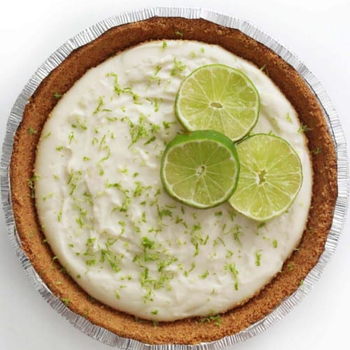 Lime pie garnished with lime zest and fresh lime slices.