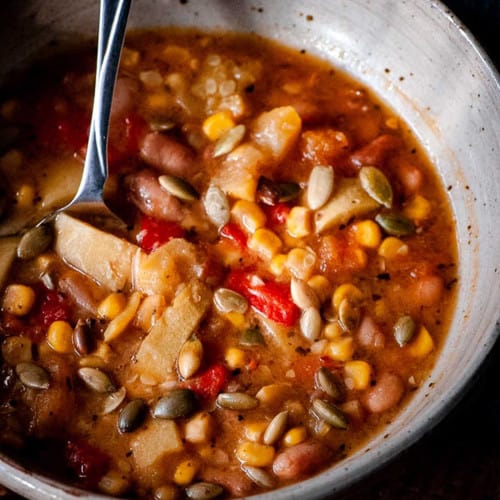 Bowl of soup made with squash, beans and corn.