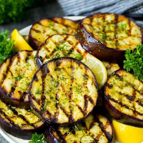 Grilled Eggplant on a dish with lemons.